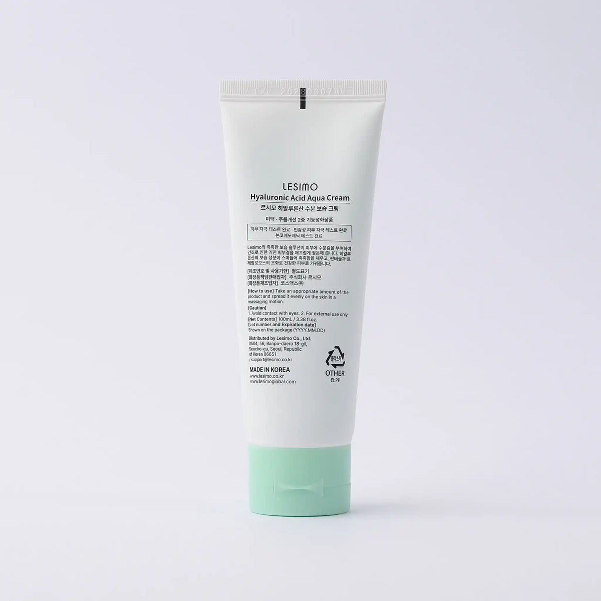 Tube of cream with green cap on a white background