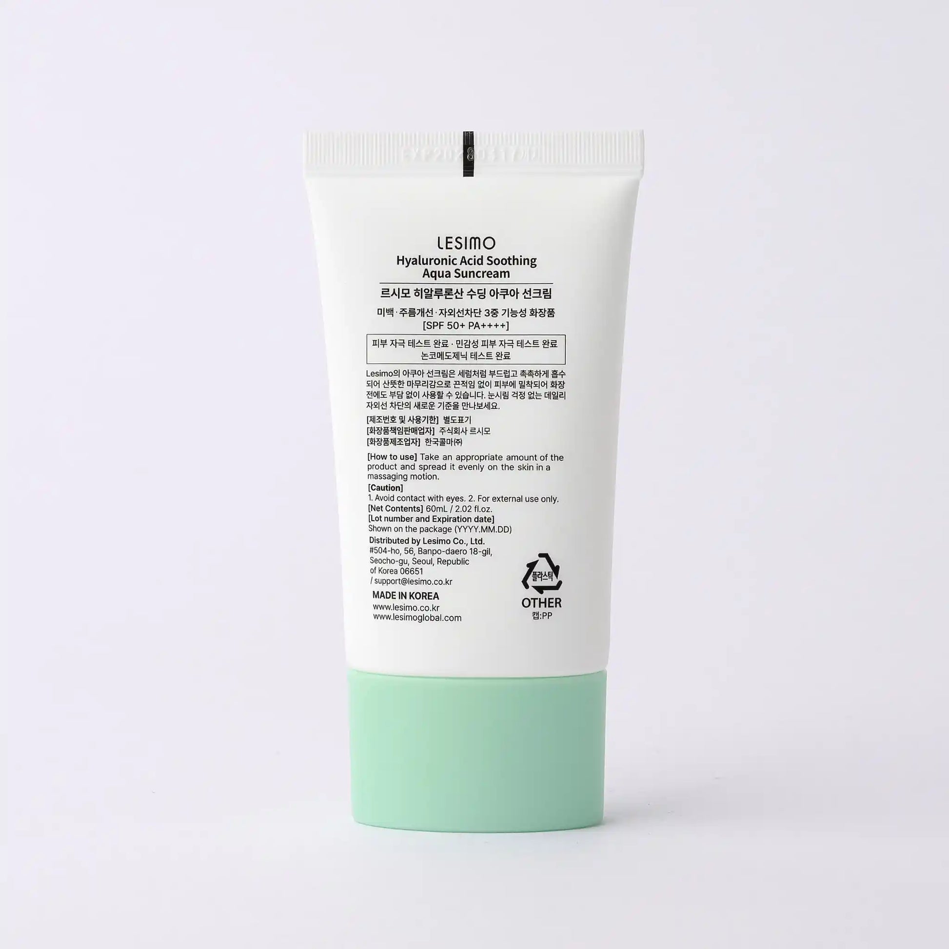 Sunscreen cream tube with green base and white label on a light gray background