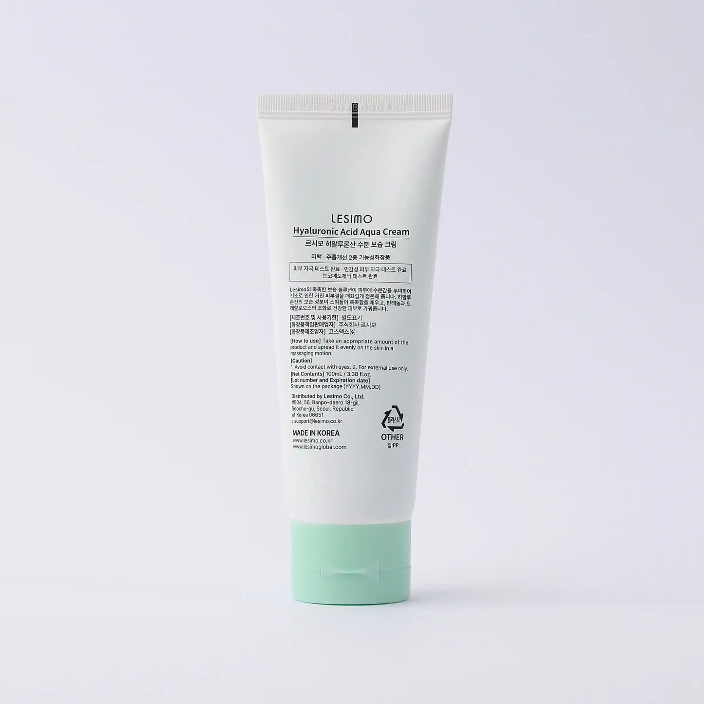 Tube of cream with green cap on a white background