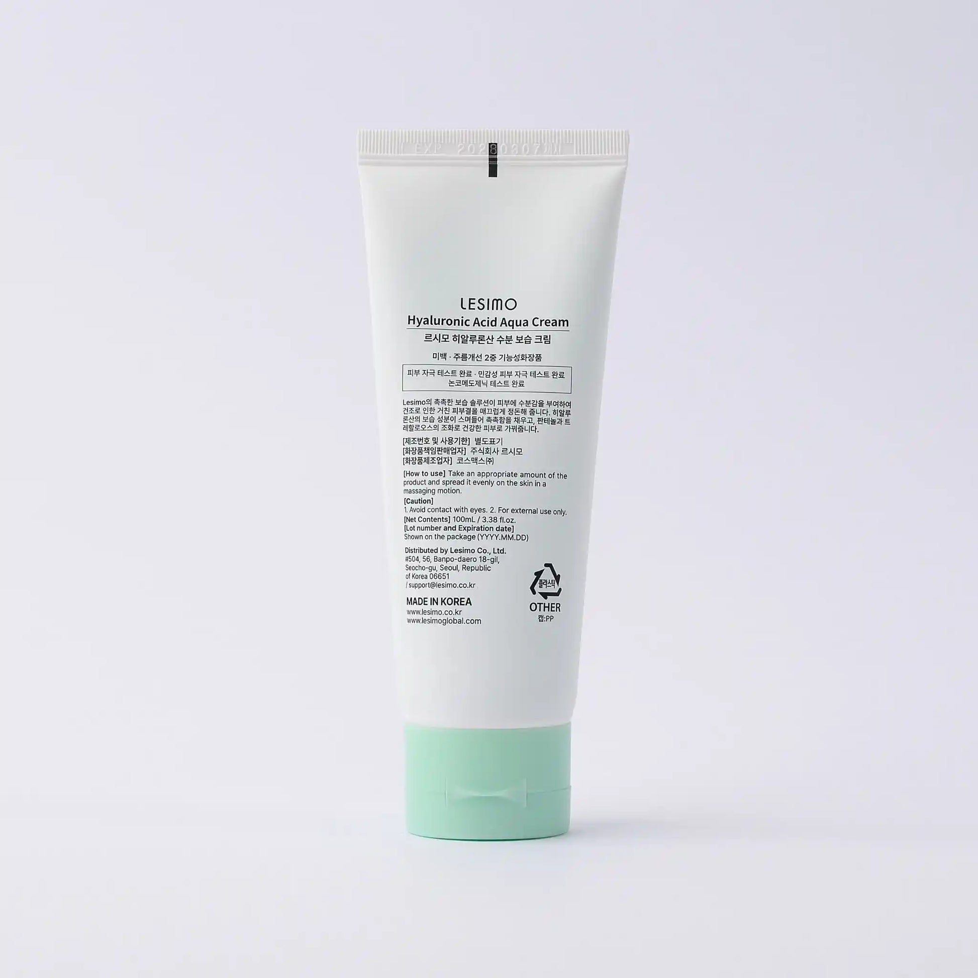 Tube of cream with green cap on a white background