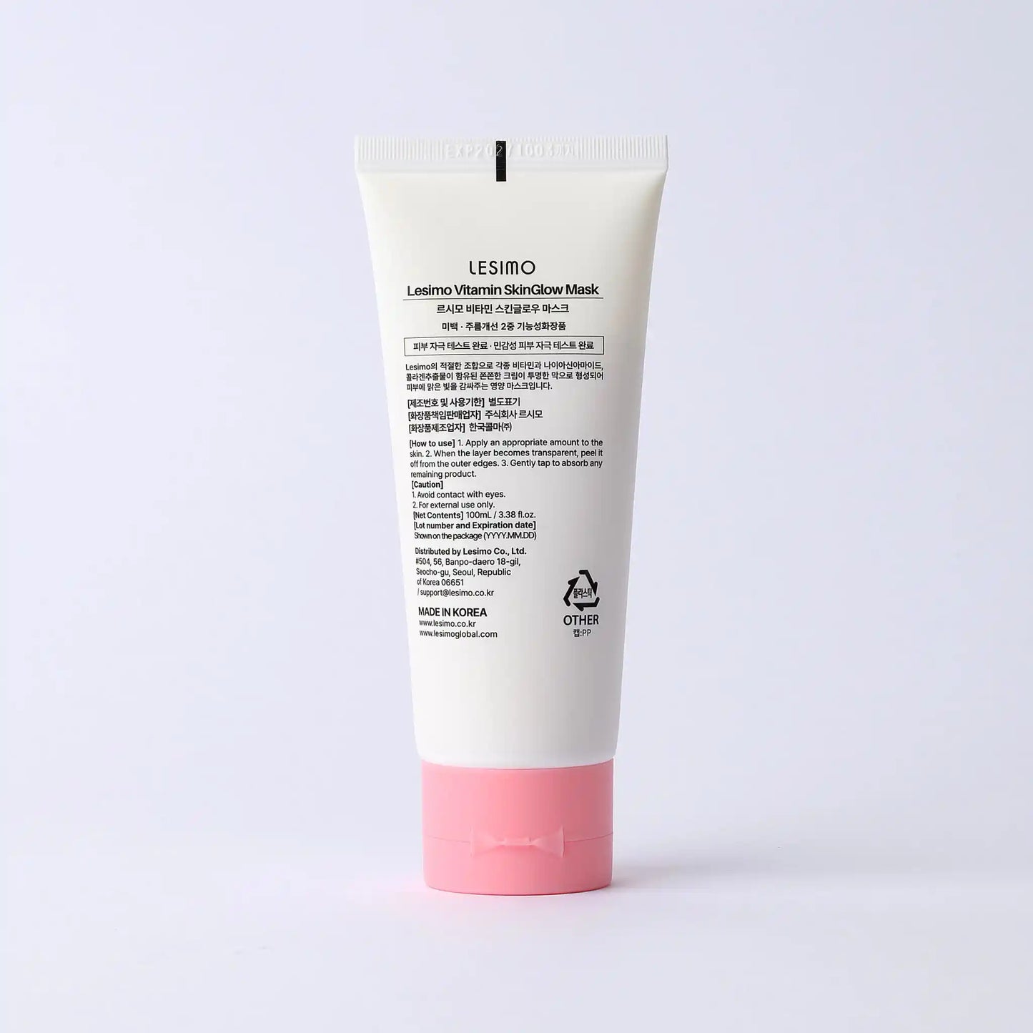 Tube of skincare product with white cap and pink base on a light gray background