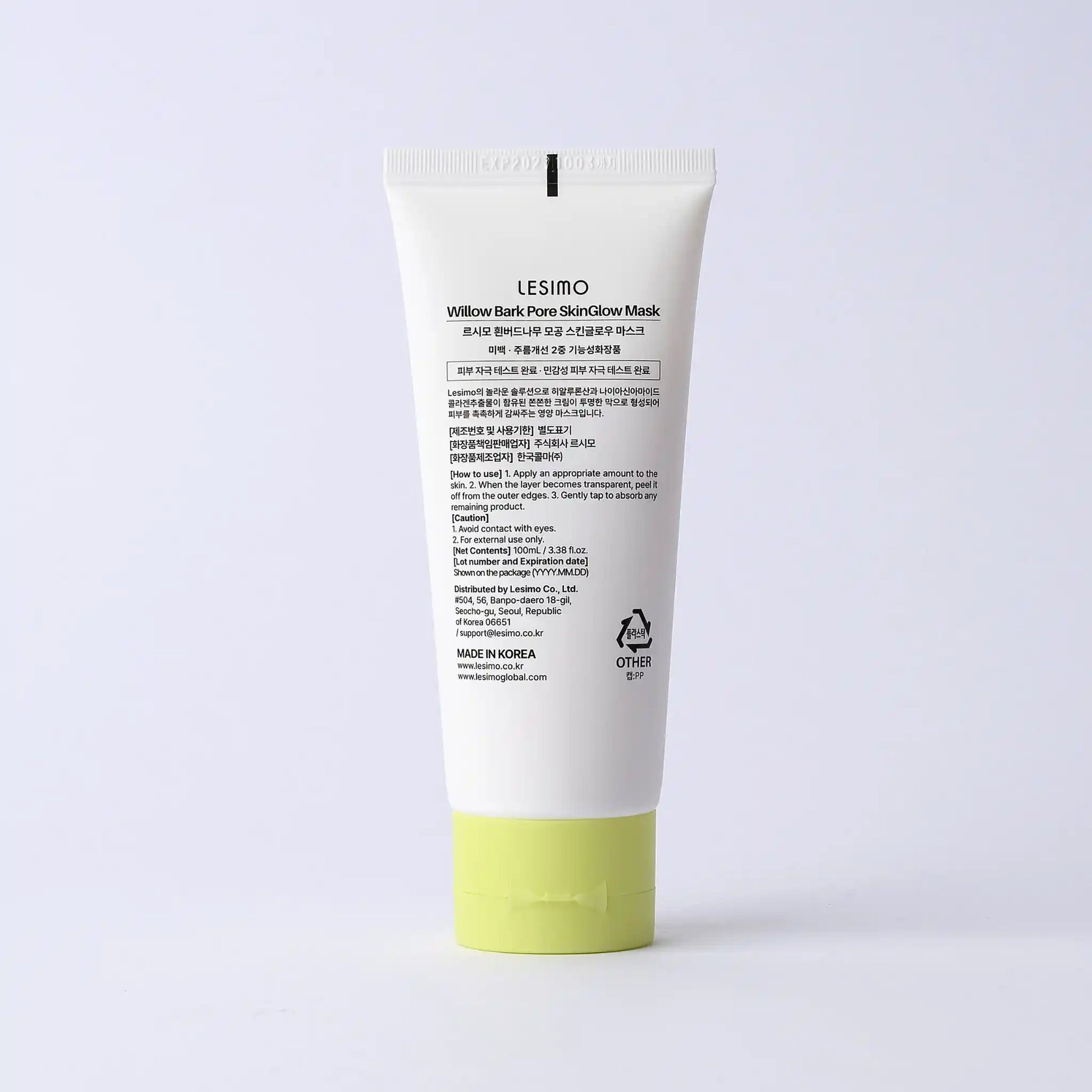 Skincare mask tube with green base on a light gray background