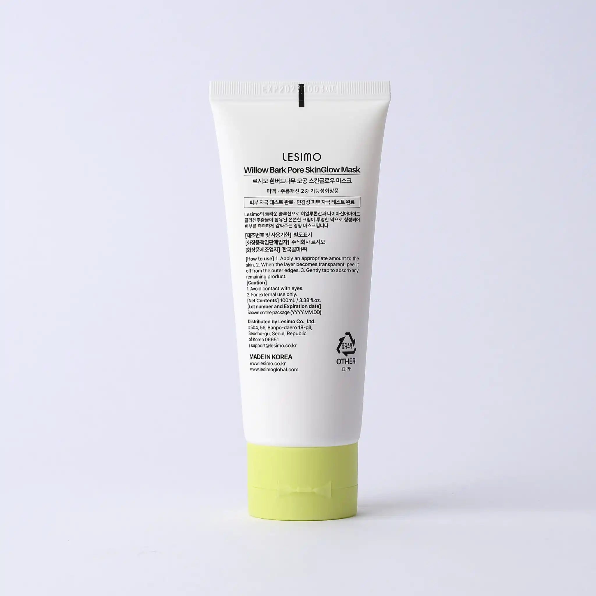 Skincare mask tube with green base on a light gray background
